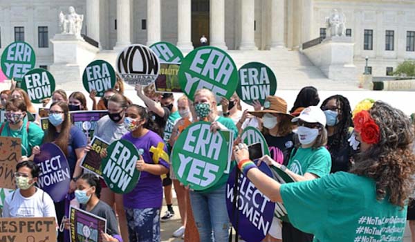 Photo of a large group of people holding signs in support of the ERA in front of the U.S. Supreme Court