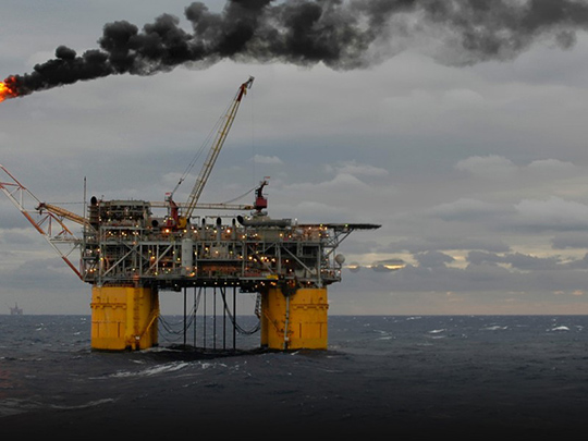 A tension-leg oil production platform burns off unrecoverable gas and leaves a plume of smoke in the Gulf of Mexico.