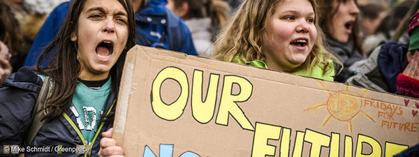 Activists hold sign demanding a better future