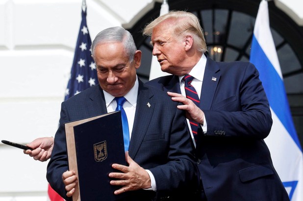Israel's Prime Minister Benjamin Netanyahu stands with U.S. President Donald Trump after signing the Abraham Accords.
