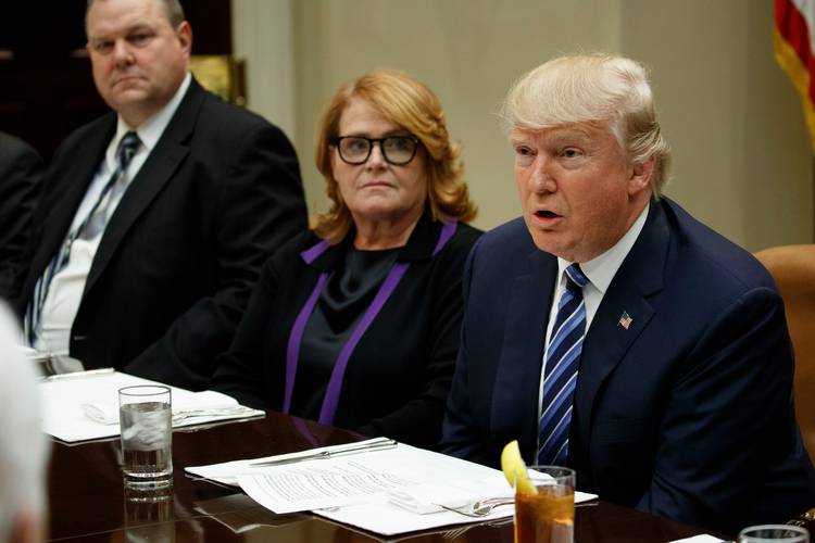 Moderate Democratic Sens. Jon Tester (Mont.) and Heidi Heitkamp (N.D.), seen here with President Trump last year, support rolling back Dodd-Frank. (Evan Vucci/AP)