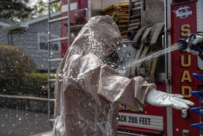 Yonkers Fire Department workers decontaminate after carrying a patient with covid-19 symptoms out of her house for emergency transport to a hospital. (John Moore/Getty Images)