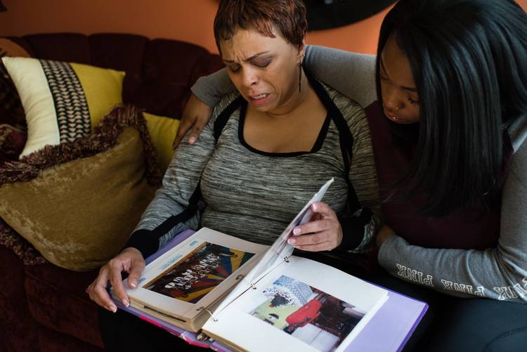 Tyreese, left, and N'Daja, right, look at a scrap book Ayana help make when she was young. (Sarah L. Voisin/The Washington Post)