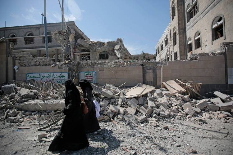 Yemenis walk past rubble after deadly airstrikes in and near the presidential compound, in Sanaa, Yemen. (Hani Mohammed/AP)