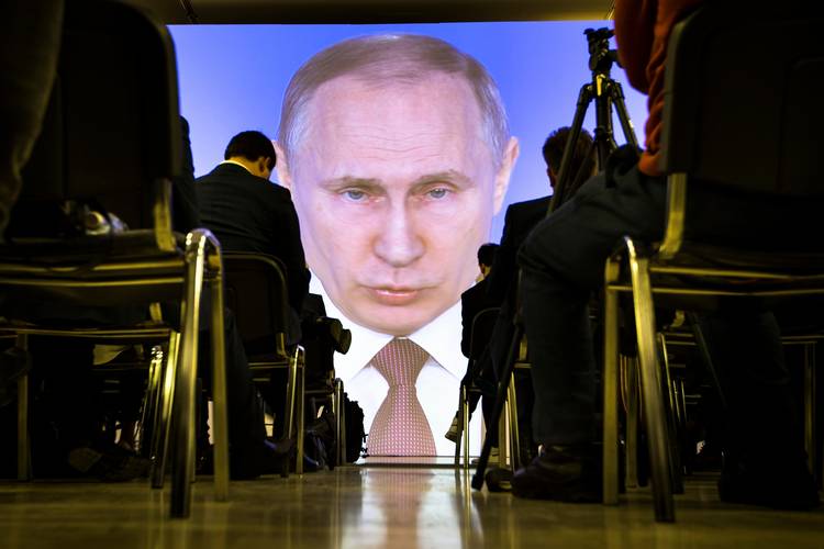 Journalists watch as Russian President Vladimir Putin gives his annual state of the nation address in Moscow. (Alexander Zemlianichenko/AP)