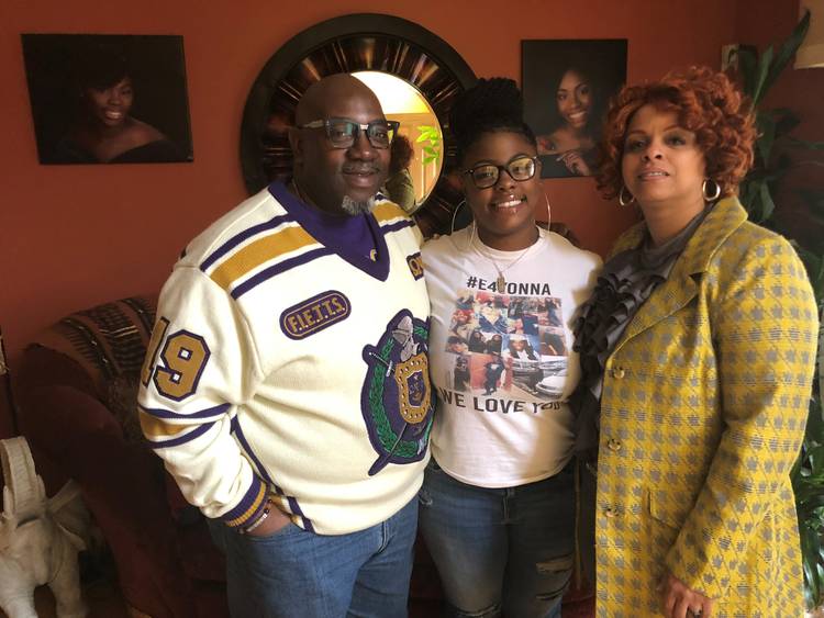 Anthony, N’Daja and Tyreese McAllister stand in the entryway of their home in Upper Marlboro, Md., on Saturday. A portrait of Ayana McAllister is on the wall behind them. (James Hohmann/The Washington Post)