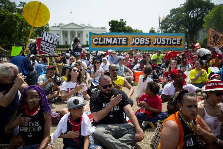 Demonstrators hold a sit-in outside the White House during the People's Climate Movement in April. (Eric Thayer/Bloomberg News)