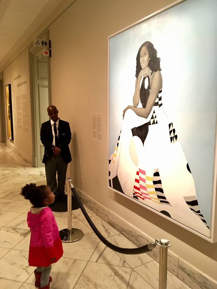 Parker Curry, 2, stands in awe of the new National Portrait Gallery painting of Michelle Obama. (Ben Hines)