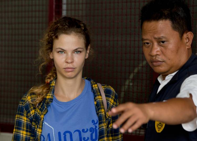 A police officer escorts Anastasia Vashukevich from a detention center last Wednesday in Pattaya, south of Bangkok, after she was arrested while giving "sex lessons” to Russian tourists. She says she fears for her life and wants to exchange information with the United States for asylum. (Gemunu Amarasinghe/AP)