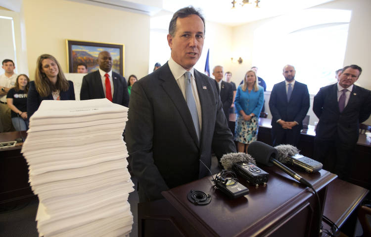 Former senator Rick Santorum (R-Pa.) stands next to a stack of letters and emails from people opposed to Medicaid expansion during a news conference at the capitol in Richmond on Wednesday. (Steve Helber/AP)