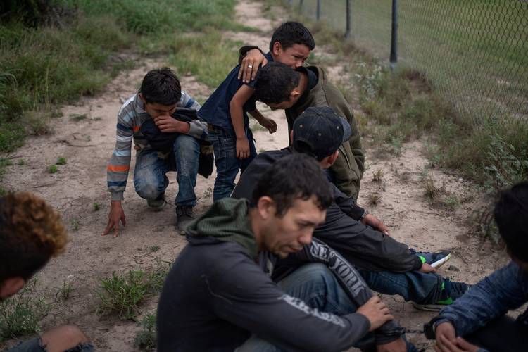 A 4-year-old boy weeps in the arms of a family member after they were apprehended by U.S. Border Patrol agents upon near McAllen, Tex., last month. (Adrees Latif/Reuters)