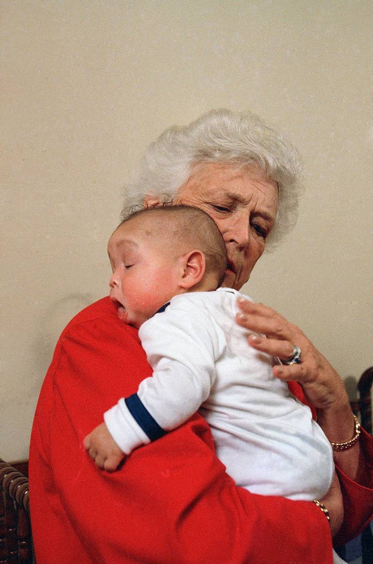 Barbara Bush, then first lady, holds an infant infected with AIDS during a 1989 visit to Grandma's House in Washington. (Dennis Cook/AP)