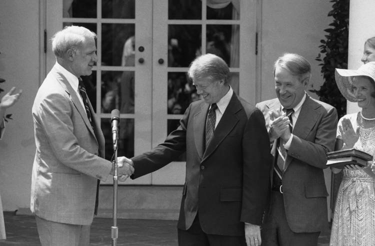 President Jimmy Carter shakes hands with Secretary of Energy James Schlesinger, left, after his 1977 swearing-in. Applauding in the Rose Garden is Sen. Henry M. Jackson (D-Wash.), who was then chairman of the Senate Energy and Natural Resources Committee. (Bob Daugherty/AP)