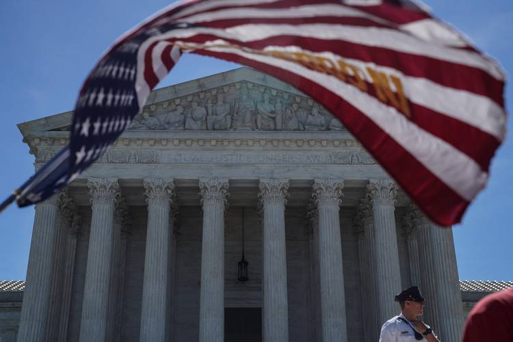 A man holds a flag outside the U.S. Supreme Court. (Toya Sarno Jordan/Reuters)
