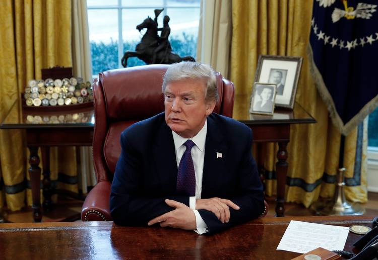 Trump sits at the Resolute Desk in the Oval Office. (Carolyn Kaster/AP)