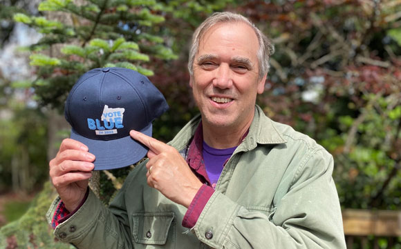 Jeff Merkley pointing at a vote blue hat