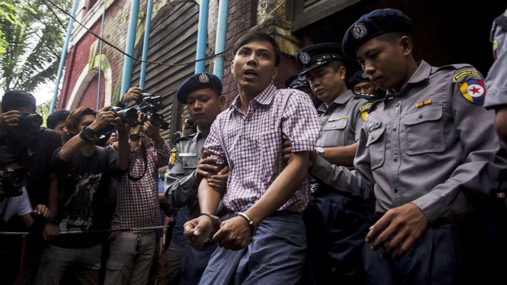 Detained Myanmar journalist Kyaw Soe Oo (C) is escorted by police out of a court in Yangon, Aug. 27, 2018.
