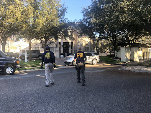 Two FBI agents outside Henry Cuellar's house