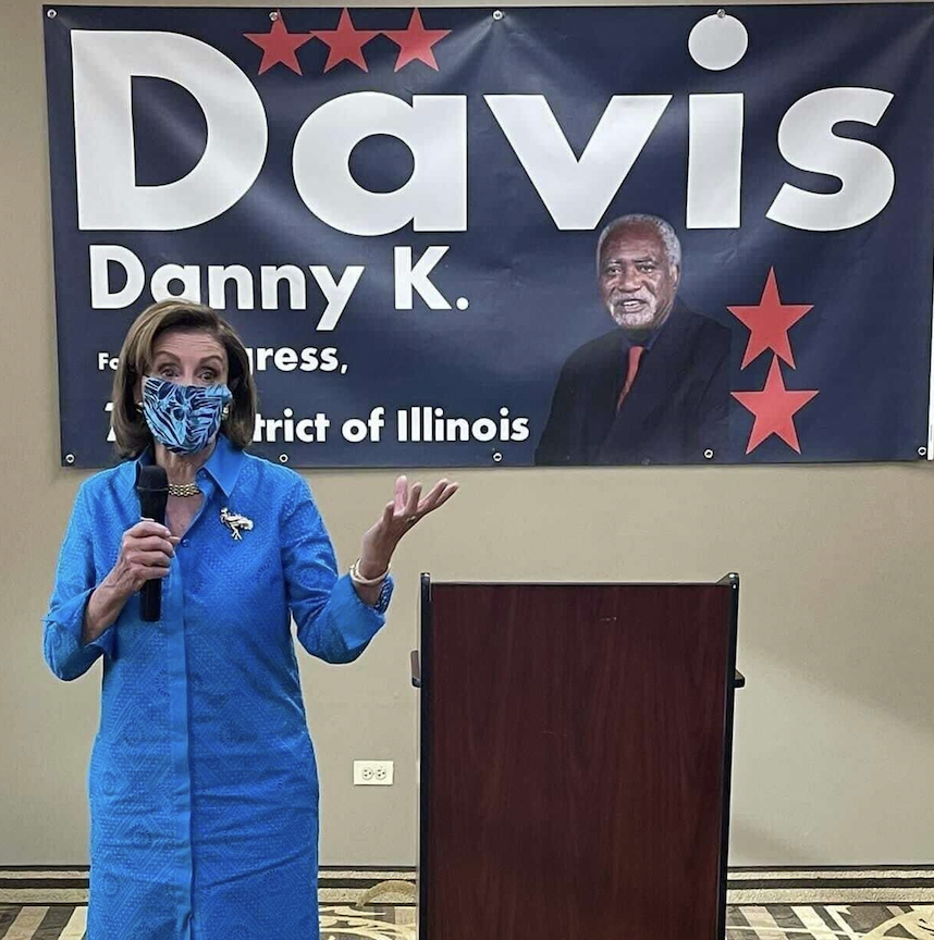 Nancy Pelosi speaking at a podium at an event for Danny Davis