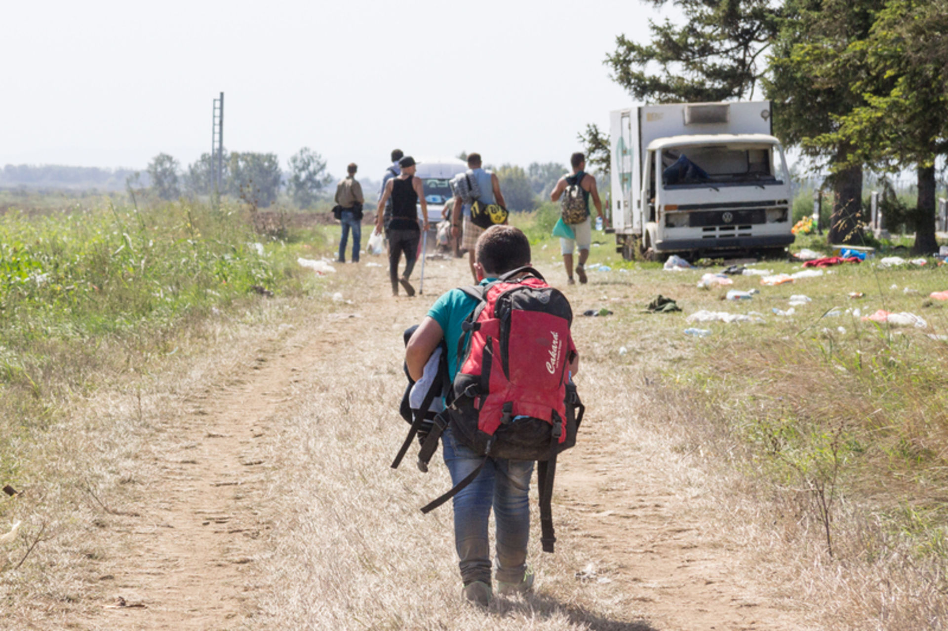 Enfant réfugié portant un gros sac à dos à la frontière entre la Croatie et la Serbie.