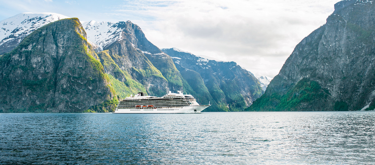 Viking ocean ship cruising through a picturesque landscape