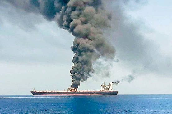 Smoke billows from an oil tanker
after an attack in the Gulf of Oman, near...