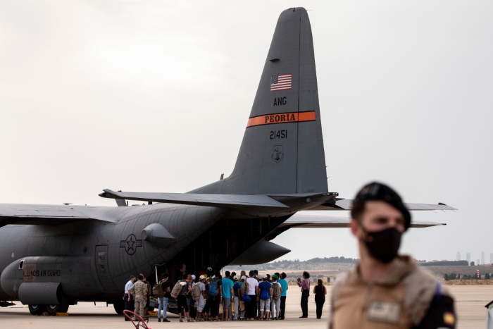 Nightly 8-24-21 photo Afghan people, who were evacuated from Kabul, queue to embark into a US air force plane at Torrejon Military Air Base in Madrid, Spain.