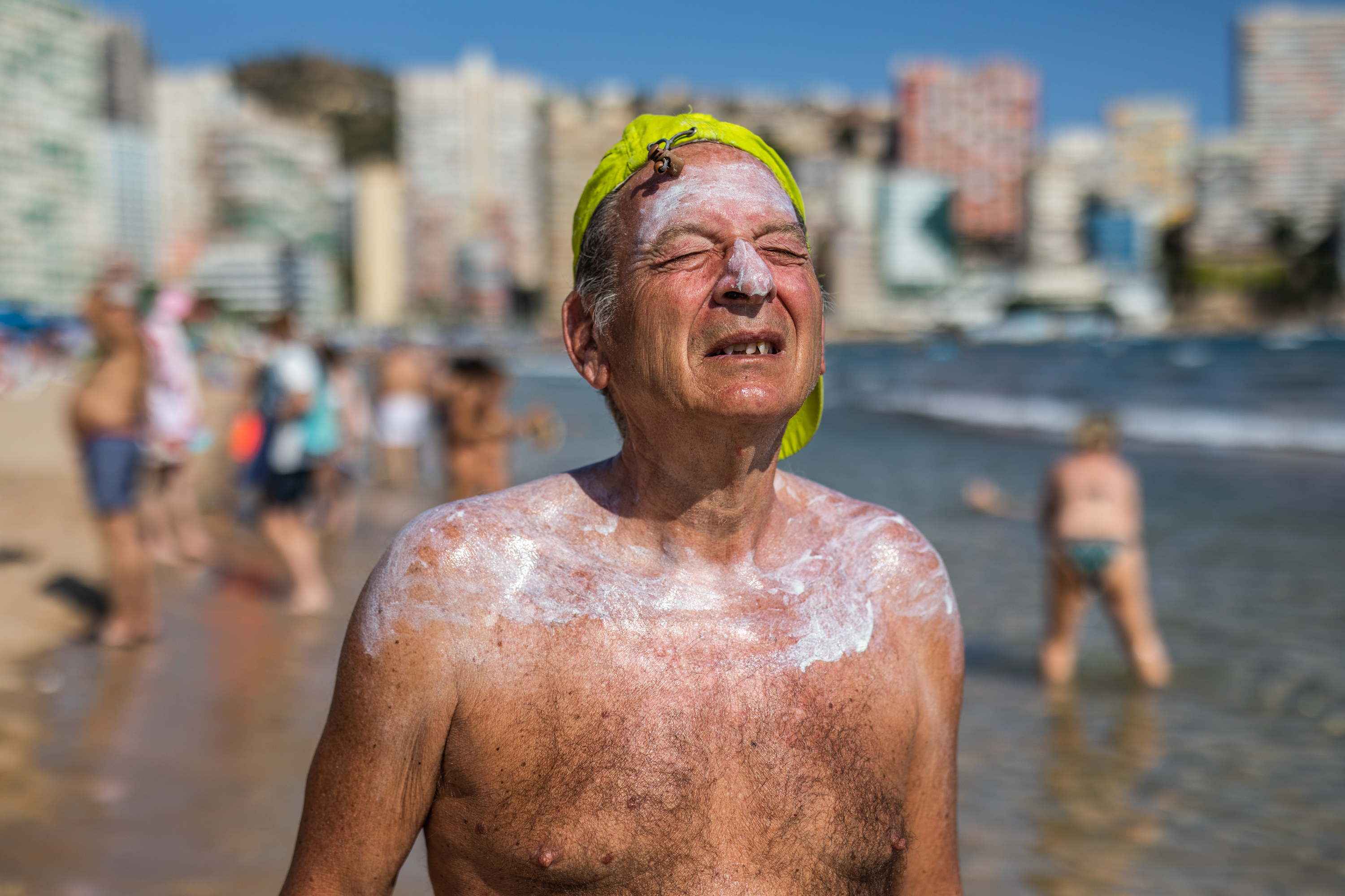 A man wears sunscreen on a beach in Spain.