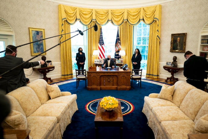 Nightly 3-30-21 photo Flanked by Vice President Kamala Harris (L) and Administrator of the Small Business Administration Isabella Casillas Guzman (R), Biden signs the Paycheck Protection Program extension in the Oval Office of the White House.