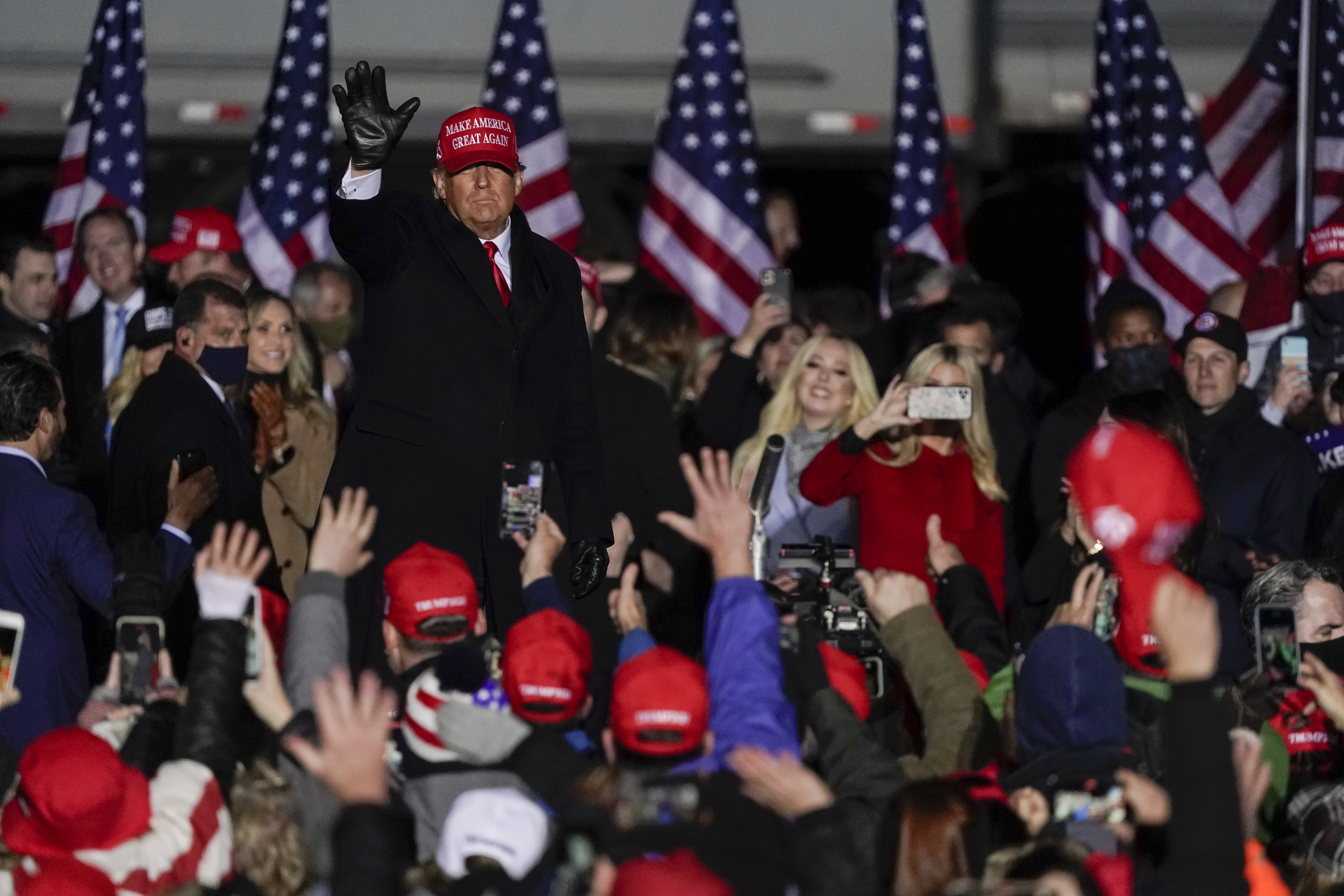 Then-President Donald Trump waves to a crowd at a campaign event the day before the 2020 election.