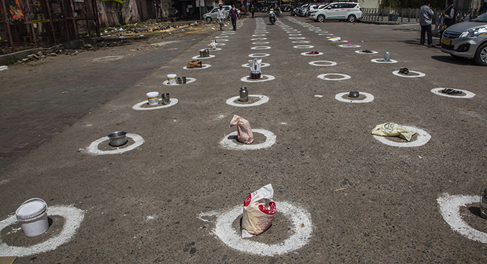 20200413_IndiaCovid_Getty_700 Utensils and bags left in circles marked on the ground in New Delhi to maintain social distancing for Indian homeless people and stranded migrant workers to get free food | Getty Images