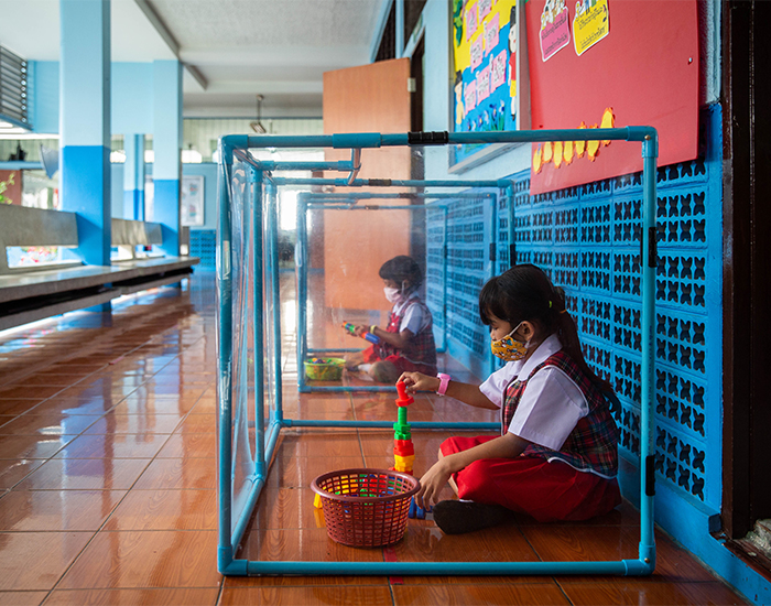 Thai kindergarteners wear face masks as they play in screened in play areas used for social distancing at the Wat Khlong Toey School on August 10, 2020 in Bangkok, Thailand. 