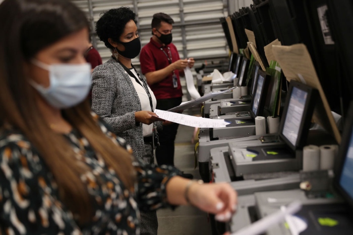 Nightly 10-15 photo Election workers check voting machines for accuracy at the Miami-Dade Election Department headquarters in Doral, Fla.
