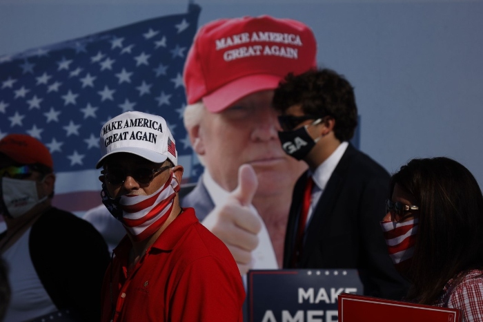 Supporters of President Donald Trump leave a Trump rally while wearing masks at Mariotti Building Products in Old Forge, Pa. Only a limited number of supporters were allowed into the outdoor venue and kept social distant using appropriately placed chairs.