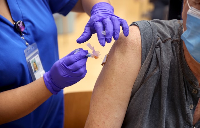 nightly-covid-vaccine-700 A nurse administers a Covid-19 booster vaccine at the VA Hospital in Hines, Ill.