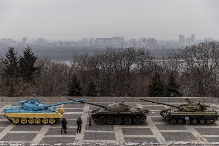 A family walks past a tank displayed at the Motherland Monument in Kyiv, Ukraine.