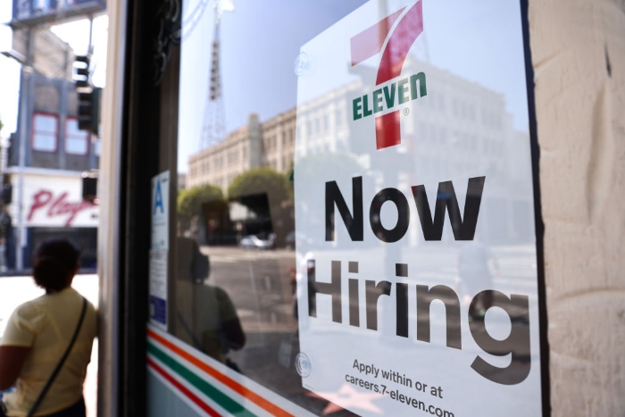 Nightly 12-22-21 photo A 'Now Hiring' sign posted at a 7-Eleven store in Los Angeles.