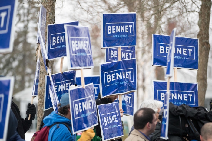 Supporters of then-Democratic presidential candidate Sen. Michael Bennet (D-Colo.) hold up signs outside of the Webster Elementary School during the presidential primary on Feb. 11, 2020, in Manchester, N.H.