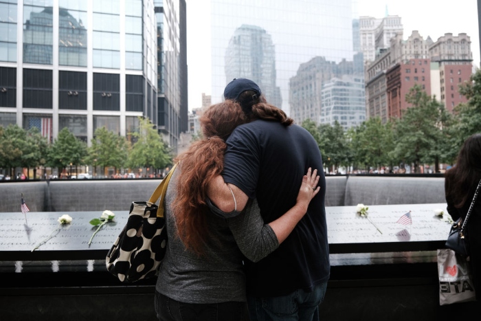 Nightly 9-10-21 photo 2 People embrace at the September 11th Memorial in New York City.