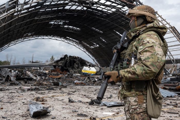 A Ukrainian serviceman stands next to the destroyed Ukrainian Antonov An-225 