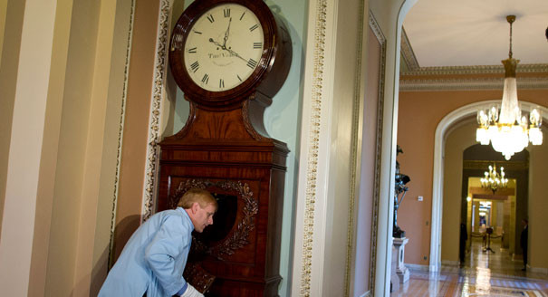 Nightly 10-4-21 photo A museum specialist for the U.S. Senate Commission on Art listens to the Ohio Clock as he restarts it outside the Senate chamber.