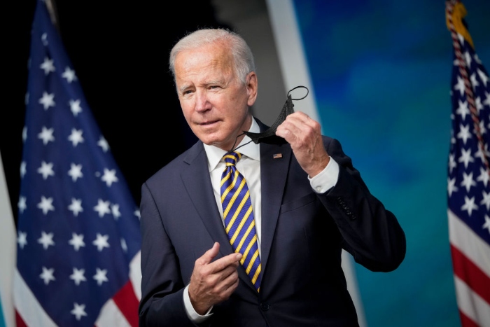 Nightly 10-20-21 photo President Joe Biden removes his face mask as he arrives to speak in the South Court Auditorium on the White House campus.
