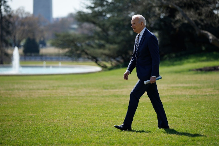 President Joe Biden walks across the South Lawn as he departs the White House.