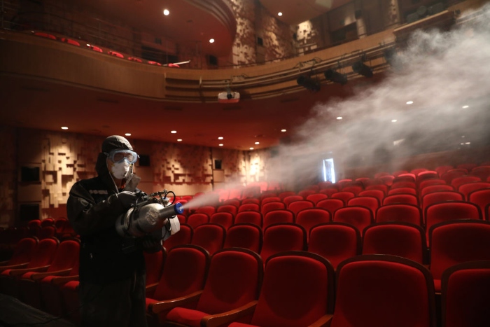 Nightly 7-21 photo A disinfection worker sprays anti-septic solution in a theater in Seoul.