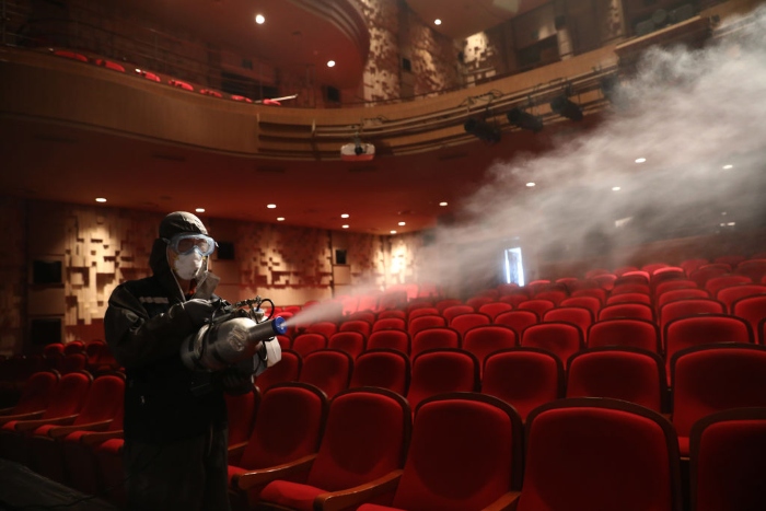 A disinfection worker sprays anti-septic solution in a theater in Seoul. 