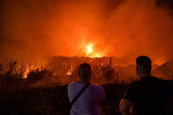 Nightly 8-3-21 photo Local residents watch a wildfire in the area of Tatoi areia in Athens.