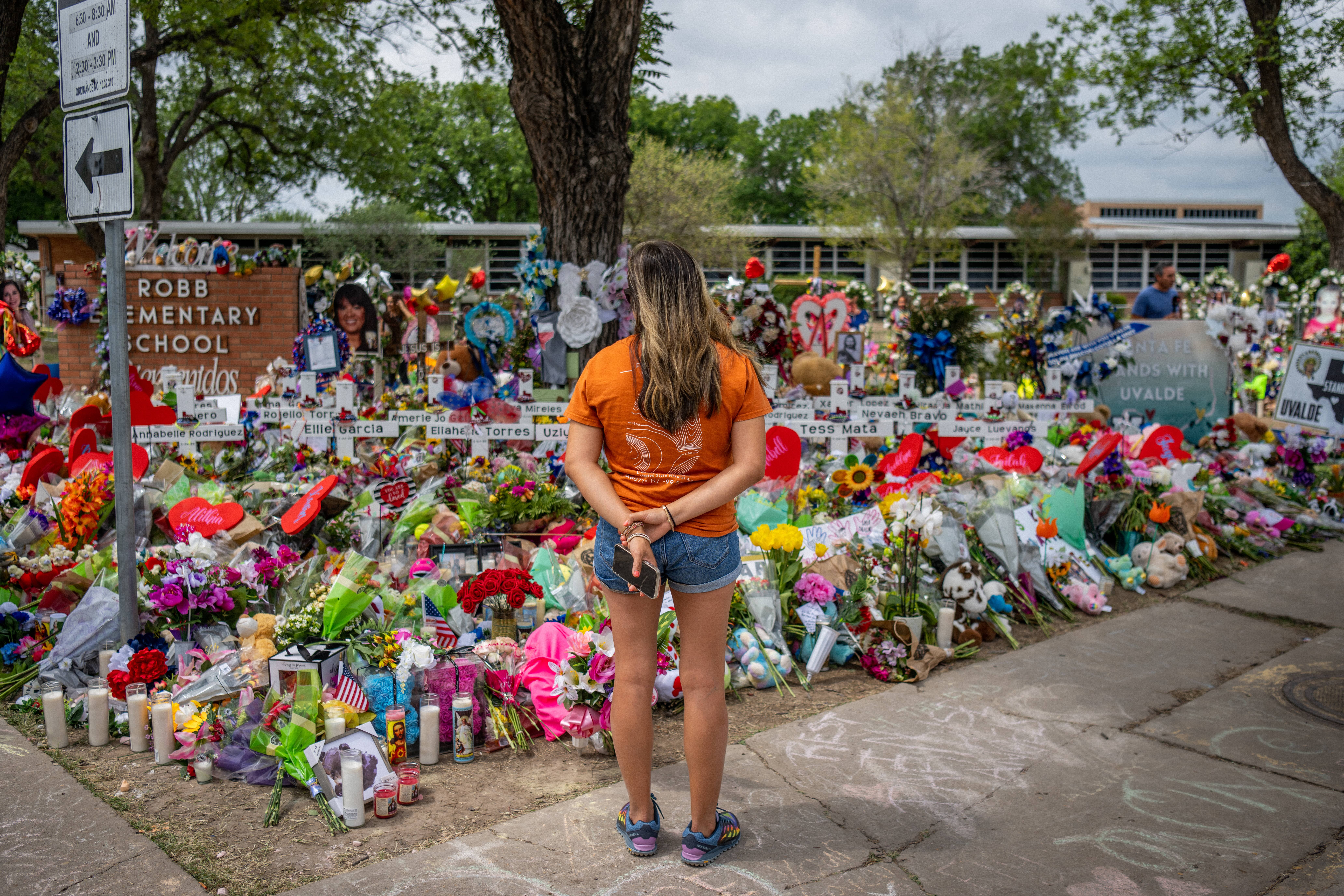 A woman stands in front of memorial dedicated to the 19 children and two adults killed on May 24 during the mass shooting at Robb Elementary School in Uvalde, Texas.