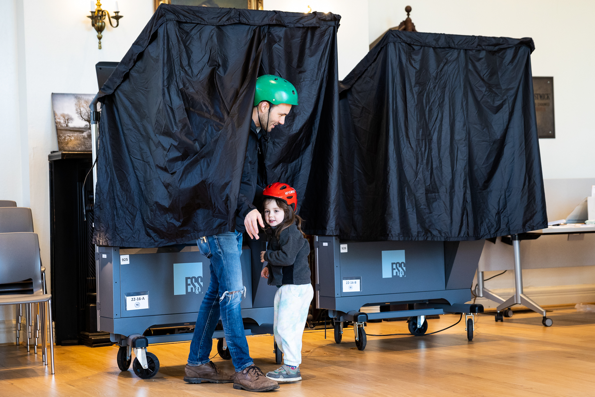 Michael Pechter and his daughter Naomi Pechter, 3, emerge from a voting booth.