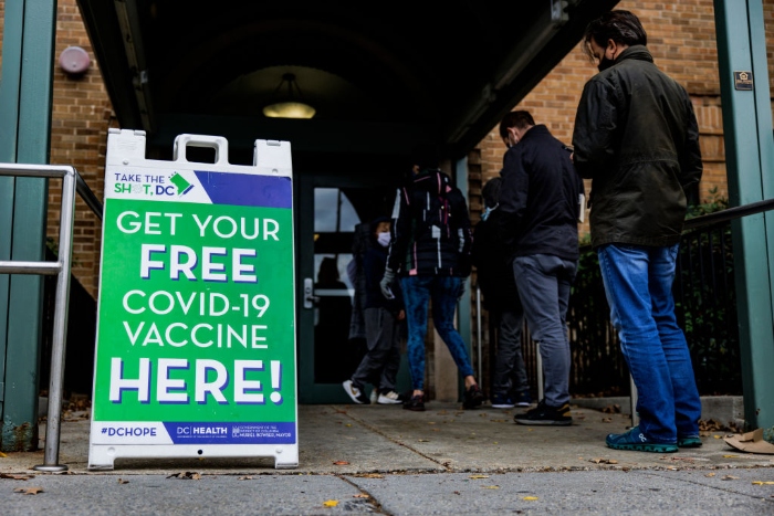 Nightly 12-10-21 photo People line up outside of a free Covid-19 vaccination site in the Hubbard Place apartment building in Washington, D.C.