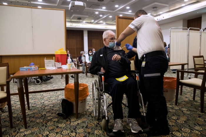 Amichai Neria, 92, receives a fourth dose of the coronavirus vaccine at a nursing home after Israel approved it for people over 60 in Tel Mond, Israel.